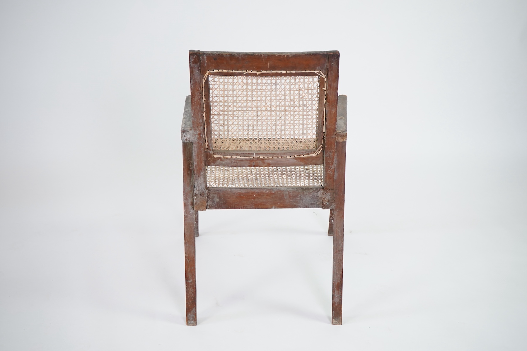 Manner of Pierre Jeanneret (Swiss, 1896-1967): A solid teak and braided canework armchair